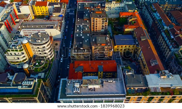 Aerial view of the city streets with cars\
moving along them. Theatrical performance is filmed from the\
cityscape at sunset. Roofs of buildings. skyscrapers. Vertical\
forest. Milan. Italy,\
20/10/2020: