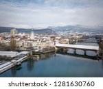 Aerial view city tower and wooden bridge in Olten, Jura mountains, Aare,  townhouse, St. Martin Church during Winter with snow on rooftops