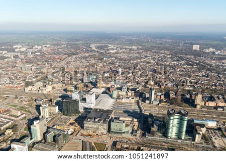 Aerial view of the city of Utrecht with the construction site at the central station and the shopping mall HOOG CATHARIJNE in the front. There is a clear horizon with a blue sky.