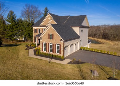 Aerial View Of Classic Colonial Luxury Estate Home In Maryland W/ Brick Facade, Double Hung Sash Windows With Shutters, Asphalt Single Roof, Double Peak Gable, Metal Roof Covered Porch, Curb Appeal