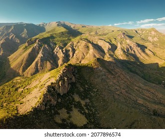 Aerial View Of Cliffs And Rocks Of The Mountains Create An Amazing Pattern Illuminated By The Rays Of The Setting Sun. Geological Outcrops And Scree Concept