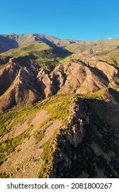 Aerial View Of Cliffs And Rocks Of The Mountains Create An Amazing Pattern Illuminated By The Rays Of The Setting Sun. Geological Outcrops And Scree Concept