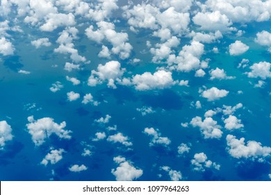 Aerial View Of Clouds And Blue Sky Over Ocean, Cloudscape Top View From Airplane