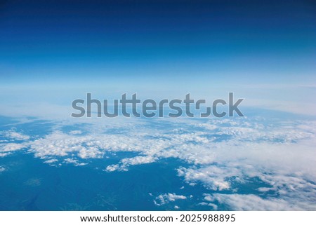 Aerial view of clouds and blue sky over ocean, cloudscape top view from airplane
