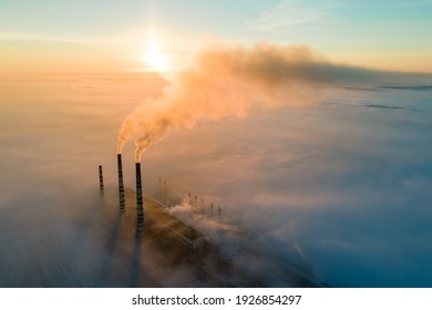 Luftbild des Kohlekraftwerks Hochrohre mit schwarzem Rauch, der bei Sonnenaufgang die verschmutzende Atmosphäre erhöht.