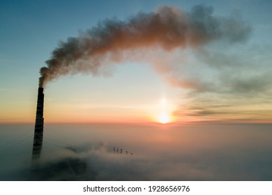 Luftbild des Kohlekraftwerks Hochrohre mit schwarzem Rauch, der bei Sonnenuntergang die verschmutzende Atmosphäre anhebt.