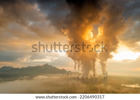 Aerial view coal power plant station in the morning mist, the morning sun rises. coal power plant and environment concept. Coal and steam. Mae Moh, Lampang, Thailand.