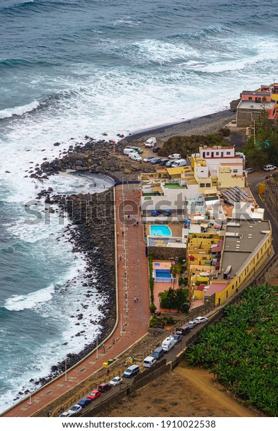 aerial view of the coast of Gran Canaria with\
houses and waves in the sea.\
Spain