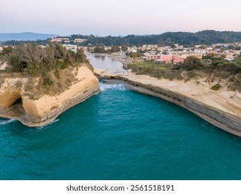 Aerial view of coastal cliffs, turquoise water, and a charming village nestled amidst greenery. - Powered by Shutterstock