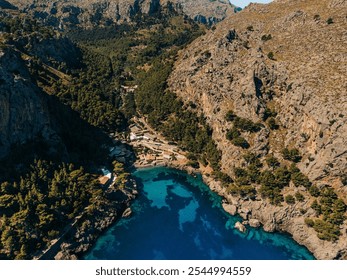 Aerial view of a coastal cove surrounded by rocky mountains and lush greenery, with clear turquoise water
 - Powered by Shutterstock