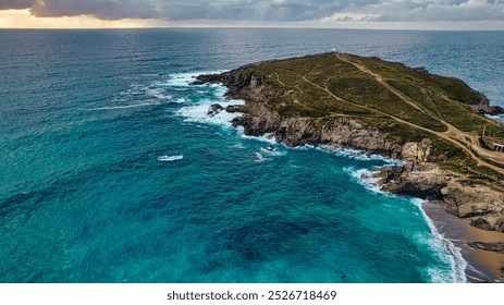 Aerial view of a coastal landscape featuring a rocky island surrounded by turquoise waters.  At Fistral Beach, Newquay, Cornwall, UK - Powered by Shutterstock