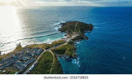 Aerial view of a coastal landscape featuring a peninsula extending into the ocean.  At Fistral Beach, Newquay, Cornwall, UK - Powered by Shutterstock