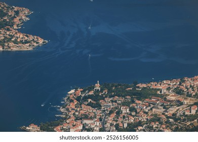 Aerial view of coastal town with azure waters and rocky coastline during bright sunny weather - Powered by Shutterstock