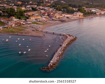 Aerial view of coastal town, beach, pier, and boats at sunset. - Powered by Shutterstock