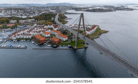 Aerial view of a coastal town with a bridge, red-roofed houses, and a marina. - Powered by Shutterstock