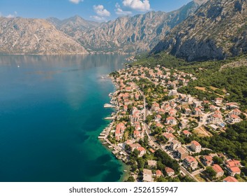 Aerial view of a coastal town nestled between mountains and sea in Montenegro during a sunny day - Powered by Shutterstock