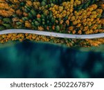 Aerial view of coastline road with autumn fall color woods and blue lakes water in Finland.