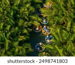 Aerial view of a coconut village basket boat tour. Palms forest in Hoi An ancient town, Cam Thanh, Vietnam. Tourists having an excursion and fun in Thu Bon river. Travel and landscape concept