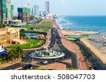 Aerial view of Colombo, Sri Lanka modern buildings with coastal promenade area. Car traffic during the day. Ocean waves