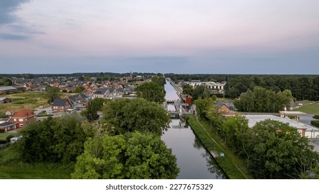 Aerial view colorful dramatic sunrise sky over canal and draw bridge in Belgium  Canals and water for transport  agriculture  Fields   meadows  Landscape  High quality photo  High quality
