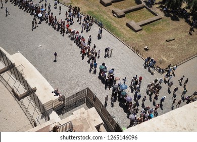 Aerial view from the Colosseum of toursists queuing on a hot day in Rome, Italy, holding parasols and umbrellas