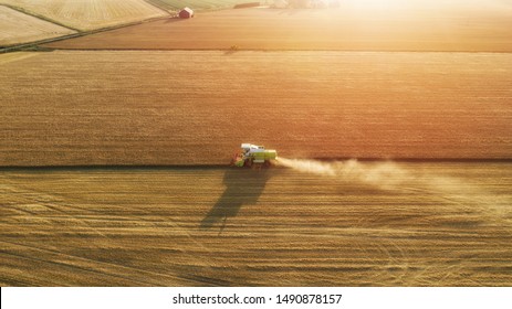 Aerial view of combine harvester harvesting wheat. Beautiful wheat field at sunset. Combine harvester working on the large wheat field. - Shutterstock ID 1490878157