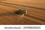 aerial view of combine harvester at work. summer field work on the farm