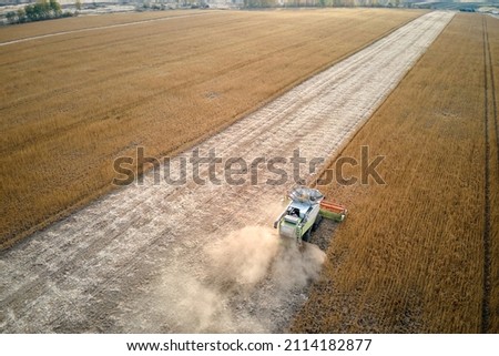 Similar – Image, Stock Photo Mähdräscher harvests a grain field in the evening light from the air