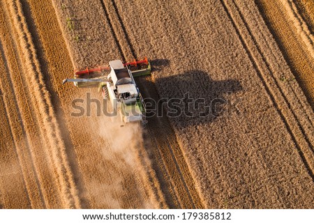 Similar – Image, Stock Photo Mähdräscher harvests a grain field in the evening light from the air