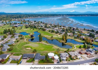 Aerial View Of A Community Of Homes With A Marina Golf Course And Ocean Views