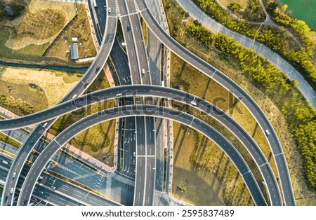 Aerial view of complex highway interchange surrounding lush greenery in daylight