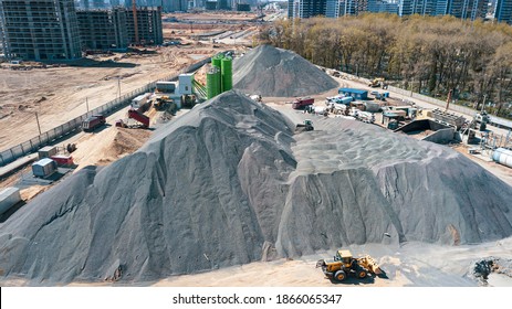 Aerial view of concrete and cement mortar plant. Concrete mixing silo for stone and sand. Bulk material storage site. Industrial concept and construction background.
