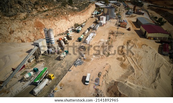 Aerial view of concrete mixing trucks and siloses of\
plant producing cement. Industrial concrete batching plant aerial\
view. 