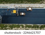 Aerial view of construction site is laying new asphalt pavement. Highway construction site scene.