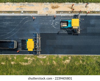 Aerial view of construction site is laying new asphalt pavement. road construction workers and road construction machinery scene. Highway construction site scene.