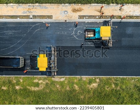 Aerial view of construction site is laying new asphalt pavement. road construction workers and road construction machinery scene. Highway construction site scene.