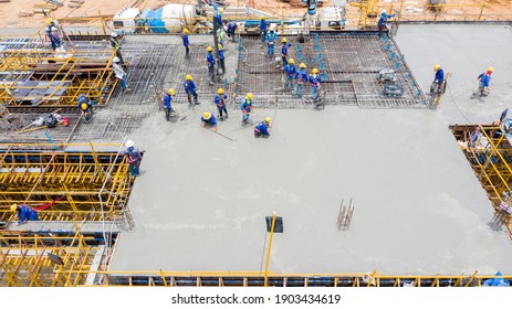 Aerial view construction worker pouring concrete floor.