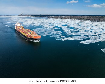 Aerial view of a container ship going upstream through winter ice in the St. Lawrence River near the port of Montreal in Canada - Powered by Shutterstock