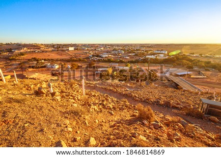 Aerial view of Coober Pedy skyline in Australian outback from lookout with main buildings of Coober Pedy city and underground town. Red desert of South Australia.