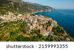 Aerial view of Corniglia and coastline of Cinque Terre,Italy.UNESCO Heritage Site.Picturesque colorful village on rock above sea.Summer holiday,travel background.Italian Riviera landscape.Steep cliff