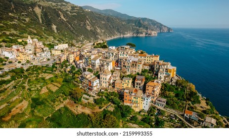 Aerial view of Corniglia and coastline of Cinque Terre,Italy.UNESCO Heritage Site.Picturesque colorful village on rock above sea.Summer holiday,travel background.Italian Riviera landscape.Steep cliff