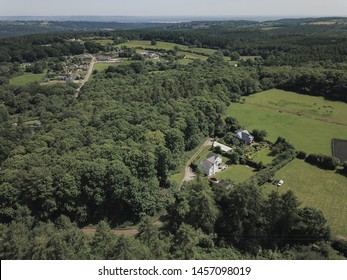 Aerial view of countryside in Europe England. Mountains, forests, woods and national park view. Small houses, buildings, roads, tracks and horizon on sunny day
