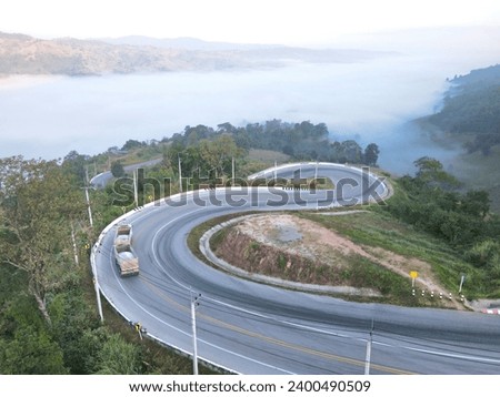 Aerial view of countryside road passing through the green forest and mountain in Thailand:Use for website banner background,backdrop

