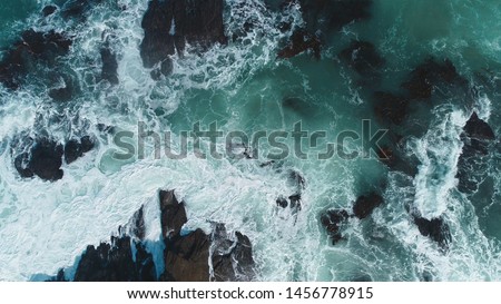 Aerial view of crashing waves on rocks. Aerial view of sea waves and fantastic Rocky coast,Background texture of a rocky shore and blue and turquoise water and waves of the Atlantic Ocean New Zealand.