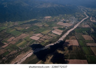 Aerial view of the cropland, fields and dried river seen from the sky.