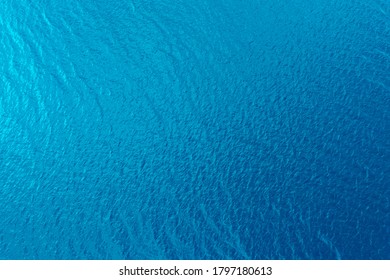 Aerial View Of A Crystal Clear Sea Water Texture. View From Above Natural Blue Background. Blue Water Reflection. Blue Ocean Wave. Summer Sea. Drone. Top View