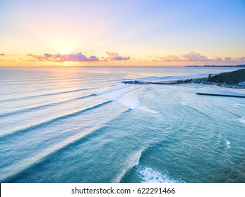 An aerial view of Currumbin Beach at sunrise with good lineup for the surfers