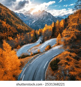 Aerial view of curvy mountain road and orange forest in golden autumn in Slovenia. Top view of winding road, colorful red trees, sky, rocks  in fall. Empty road in woods. Landscape with roadway - Powered by Shutterstock