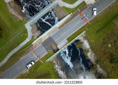 Aerial View Of Damaged Road Bridge Over River After Flood Water Washed Away Asphalt. Rebuilding Of Ruined Transportation Infrastructure