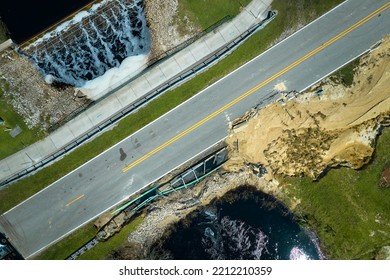 Aerial View Of Damaged Road Bridge Over River After Flood Water Washed Away Asphalt. Rebuilding Of Ruined Transportation Infrastructure